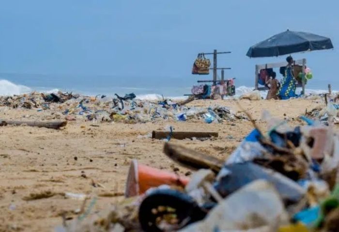 plage recouverte de déchets avec un parasol